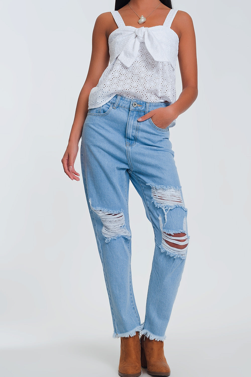Jeans azul claro de cintura alta com rasgos nos joelhos