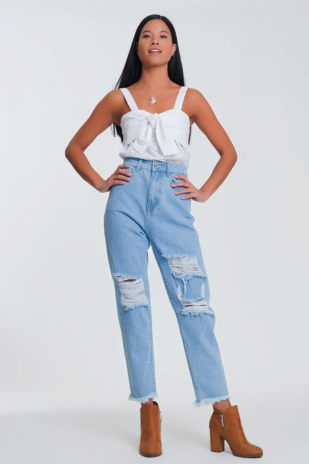 Jeans azul claro de cintura alta com rasgos nos joelhos