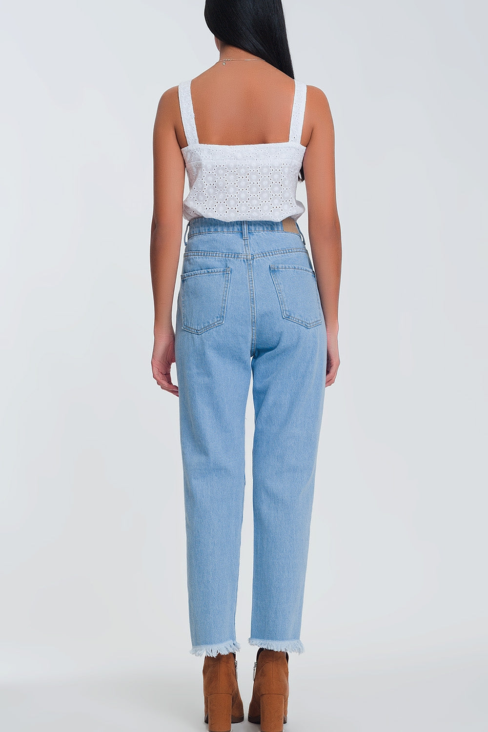 Jeans azul claro de cintura alta com rasgos nos joelhos