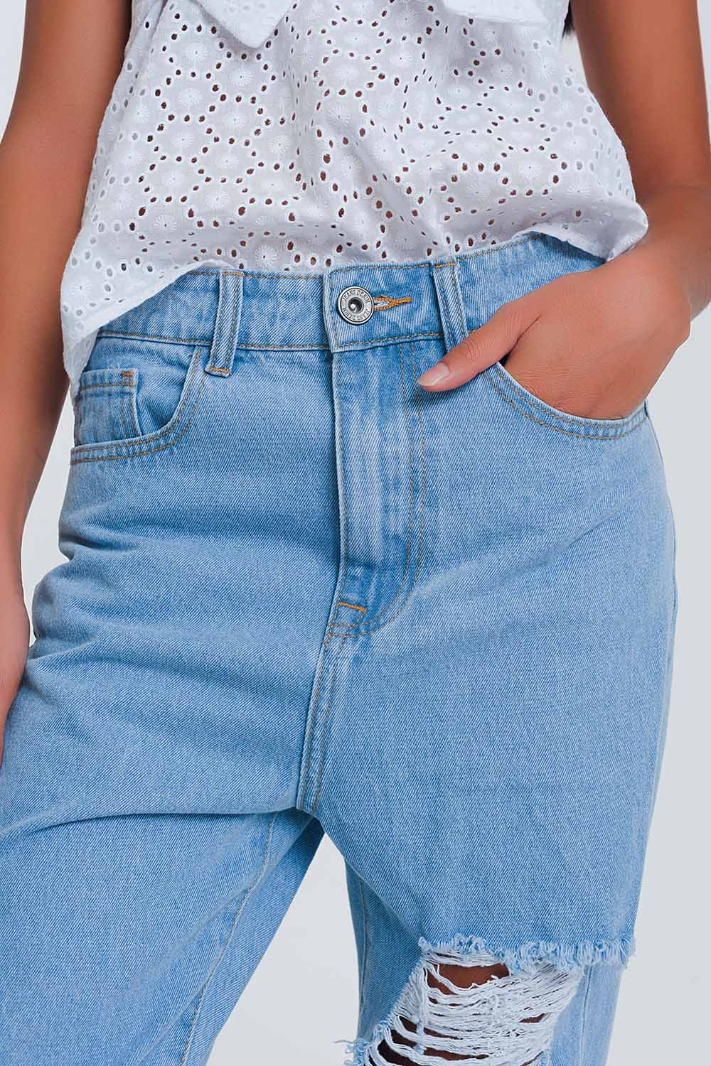 Jeans azul claro de cintura alta com rasgos nos joelhos