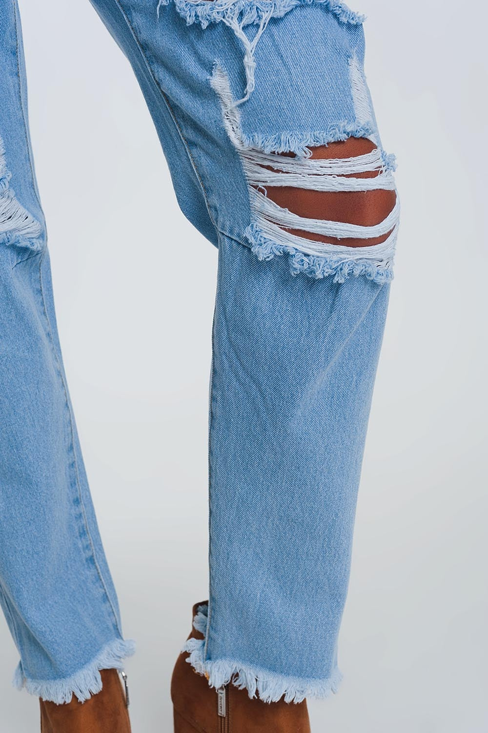 Jeans azul claro de cintura alta com rasgos nos joelhos