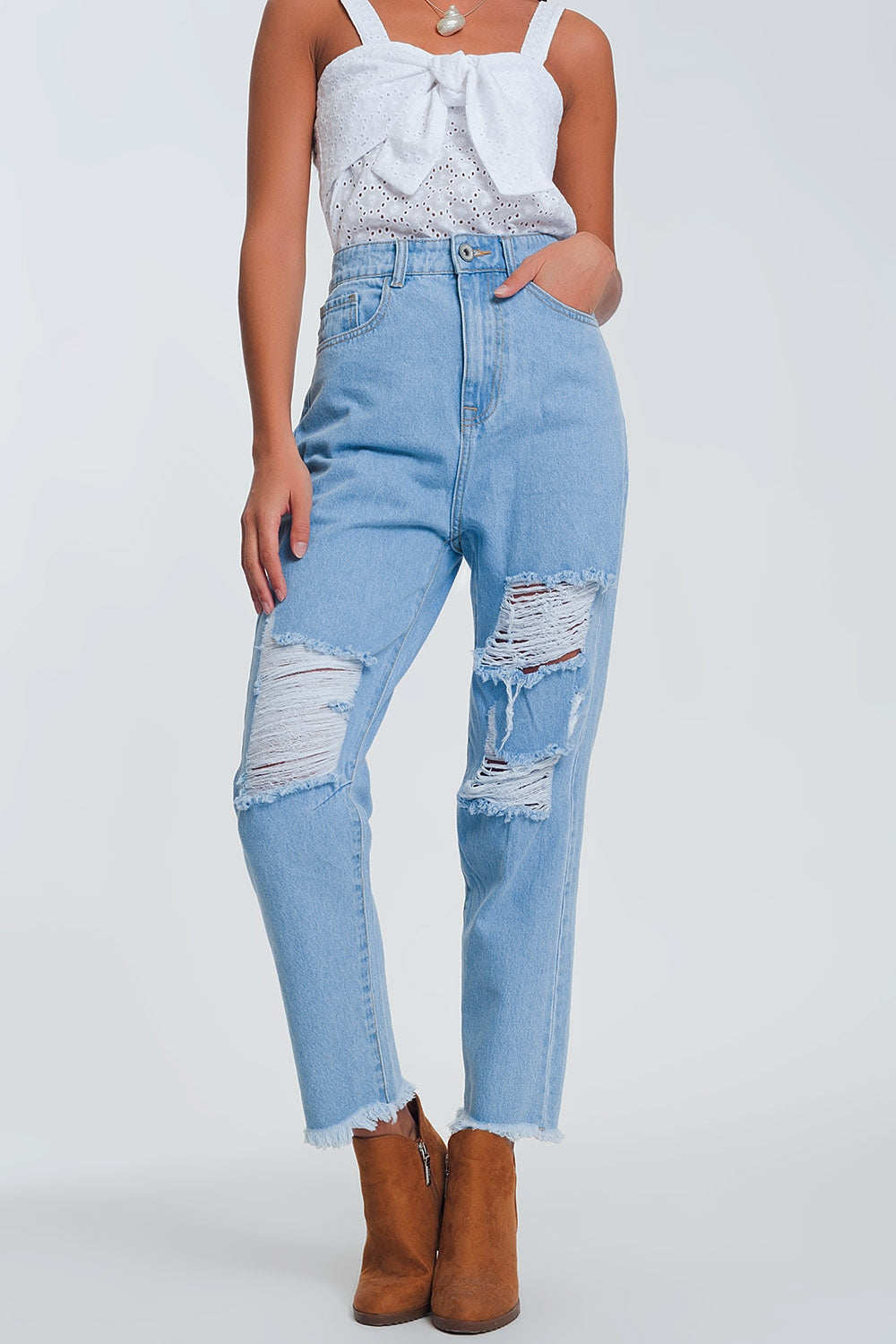 Jeans azul claro de cintura alta com rasgos nos joelhos