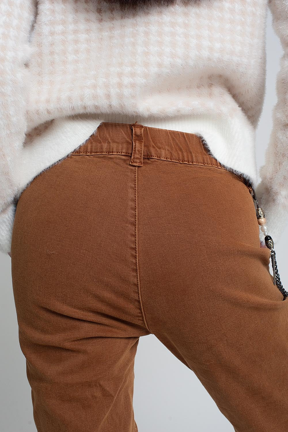 Calça com elástico na parte inferior e corrente marrom