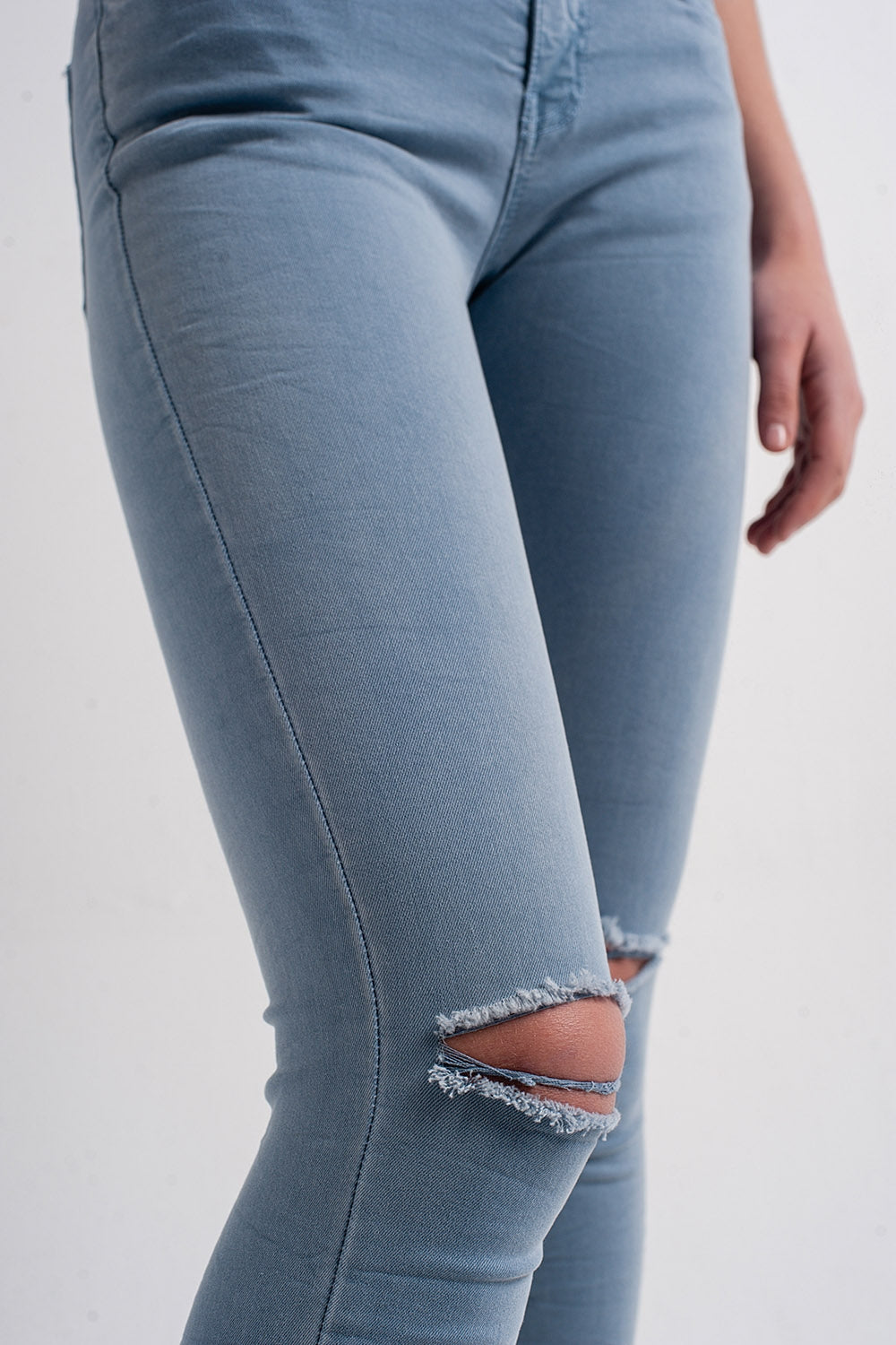 Calças de ganga azul skinny com rasgões nos joelhos