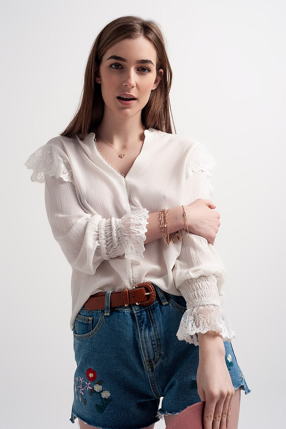 Blusa com volume nas mangas e rufos nos punhos em cor creme.
