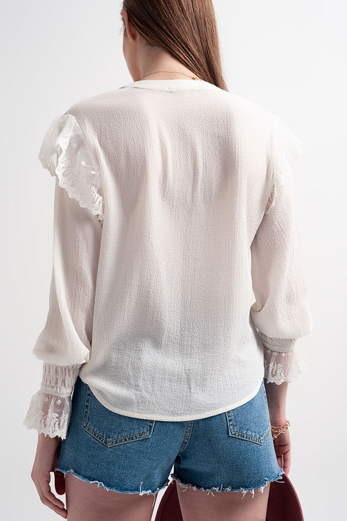 Blusa com volume nas mangas e rufos nos punhos em cor creme.