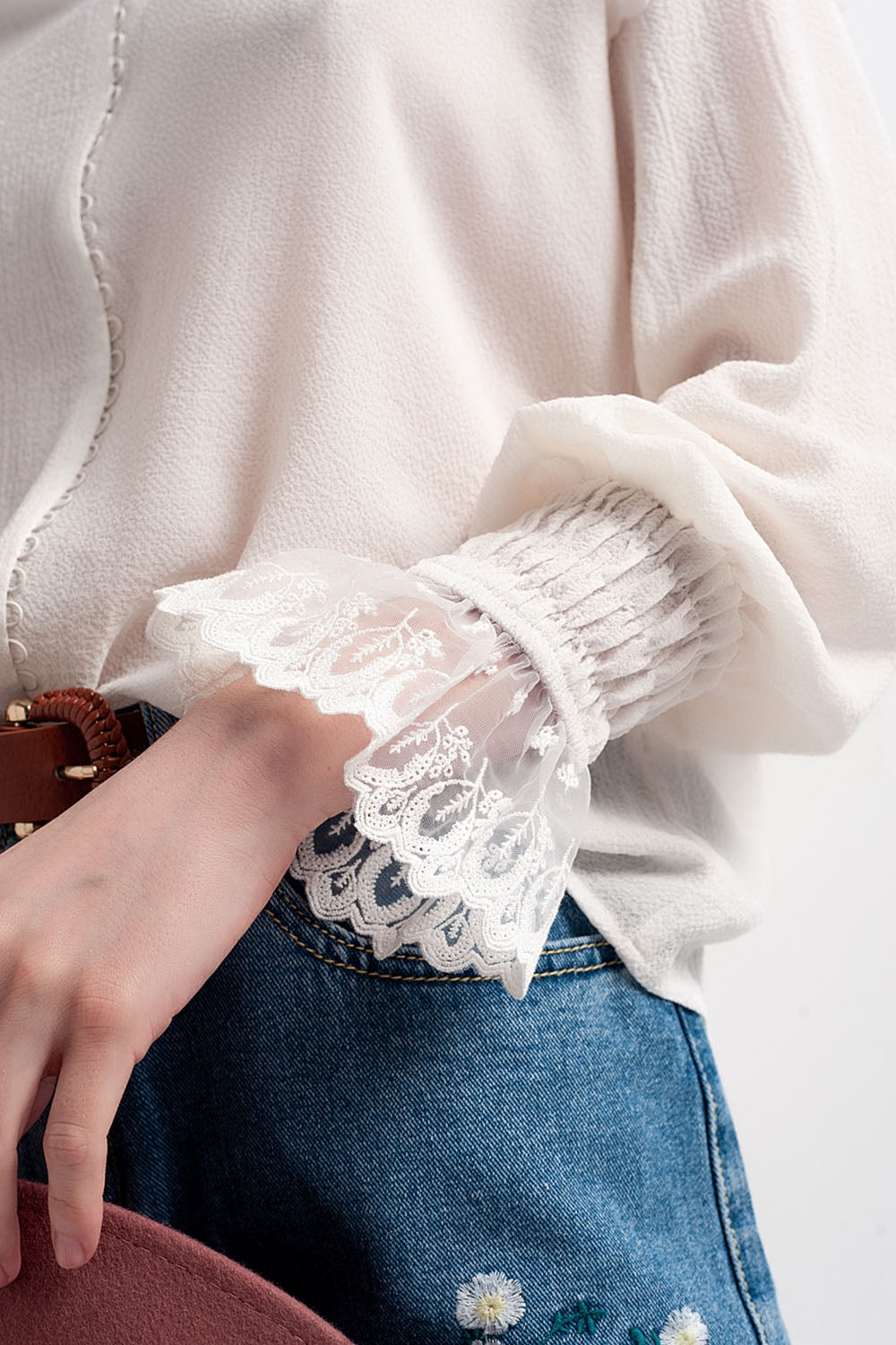Blusa com volume nas mangas e rufos nos punhos em cor creme.