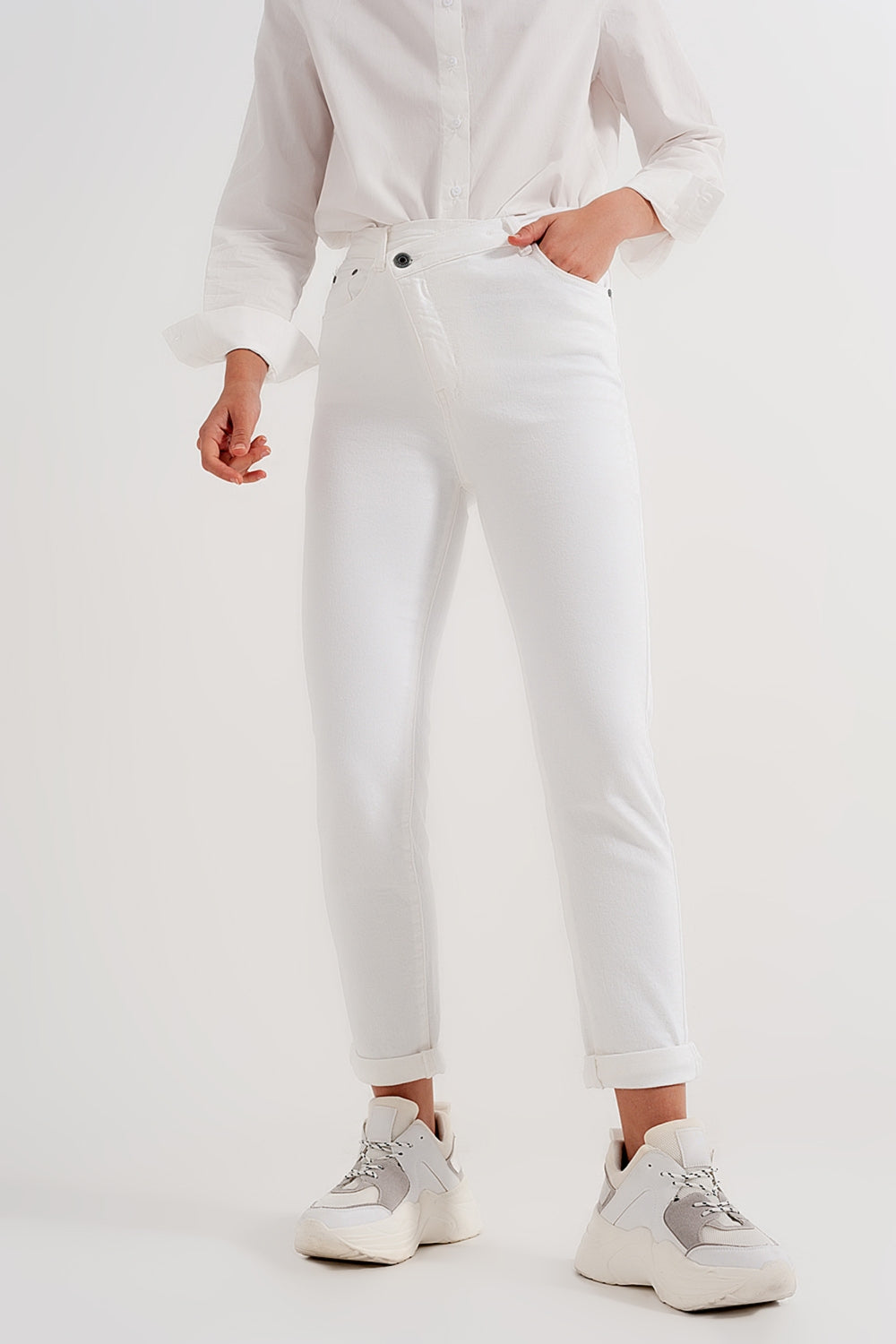 Calças de ganga slim fit com fecho e botão assimétrico em creme