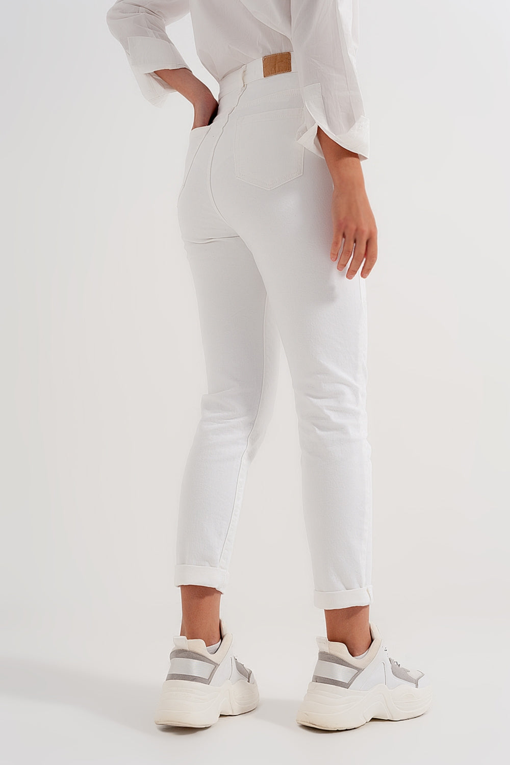Calças de ganga slim fit com fecho e botão assimétrico em creme