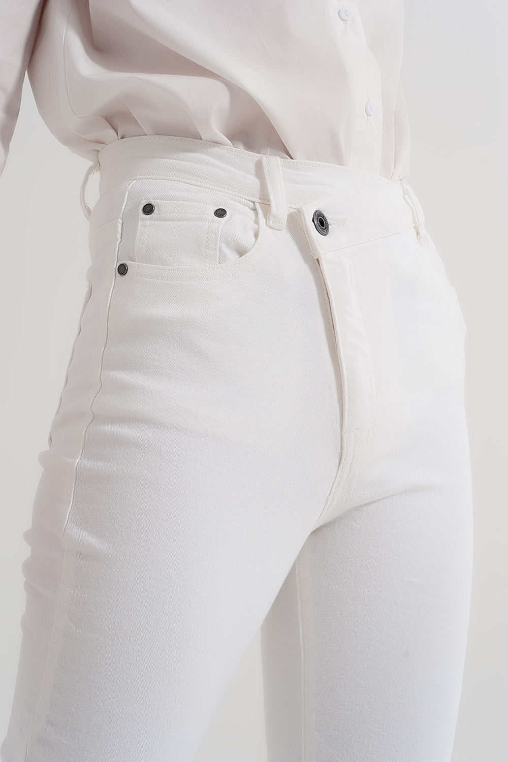 Calças de ganga slim fit com fecho e botão assimétrico em creme