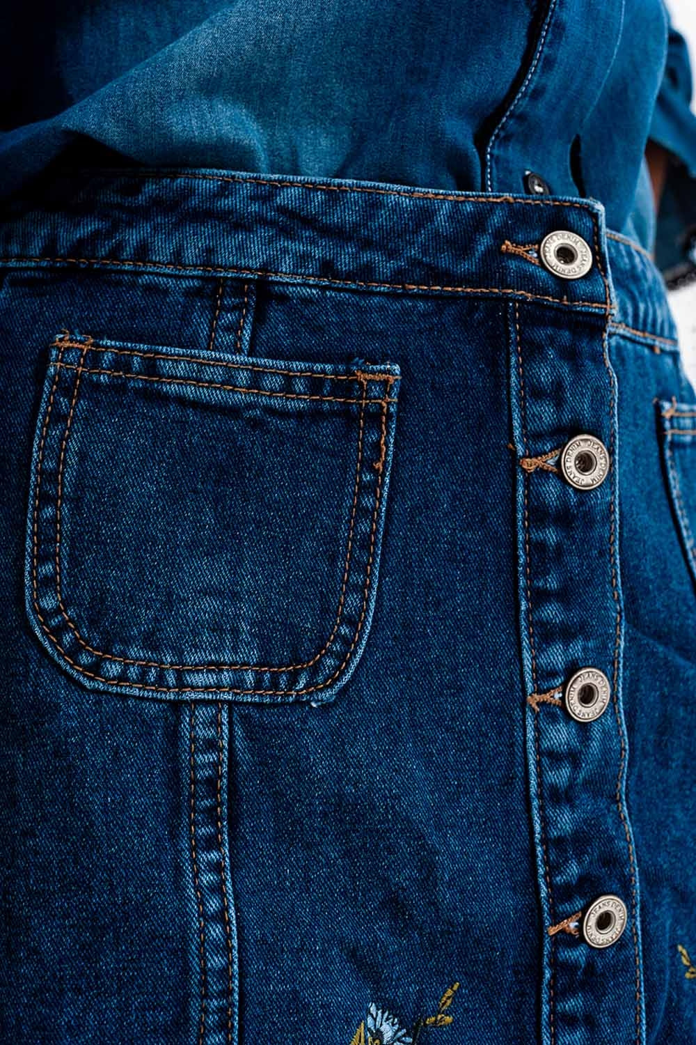 Saia jeans com flores bordadas e botões frontais