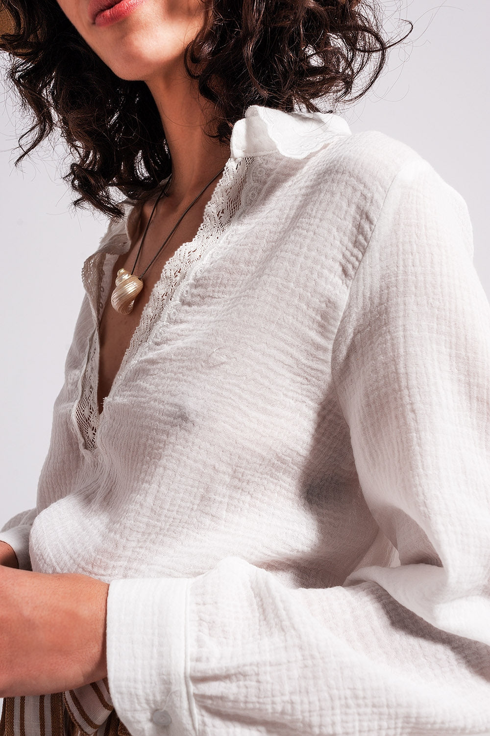 Blusa de cor creme com detalhes de decote em V e renda