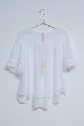 Blusa branca com laçada na frente e bordados