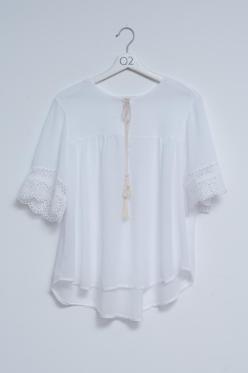 Blusa branca com laçada na frente e bordados