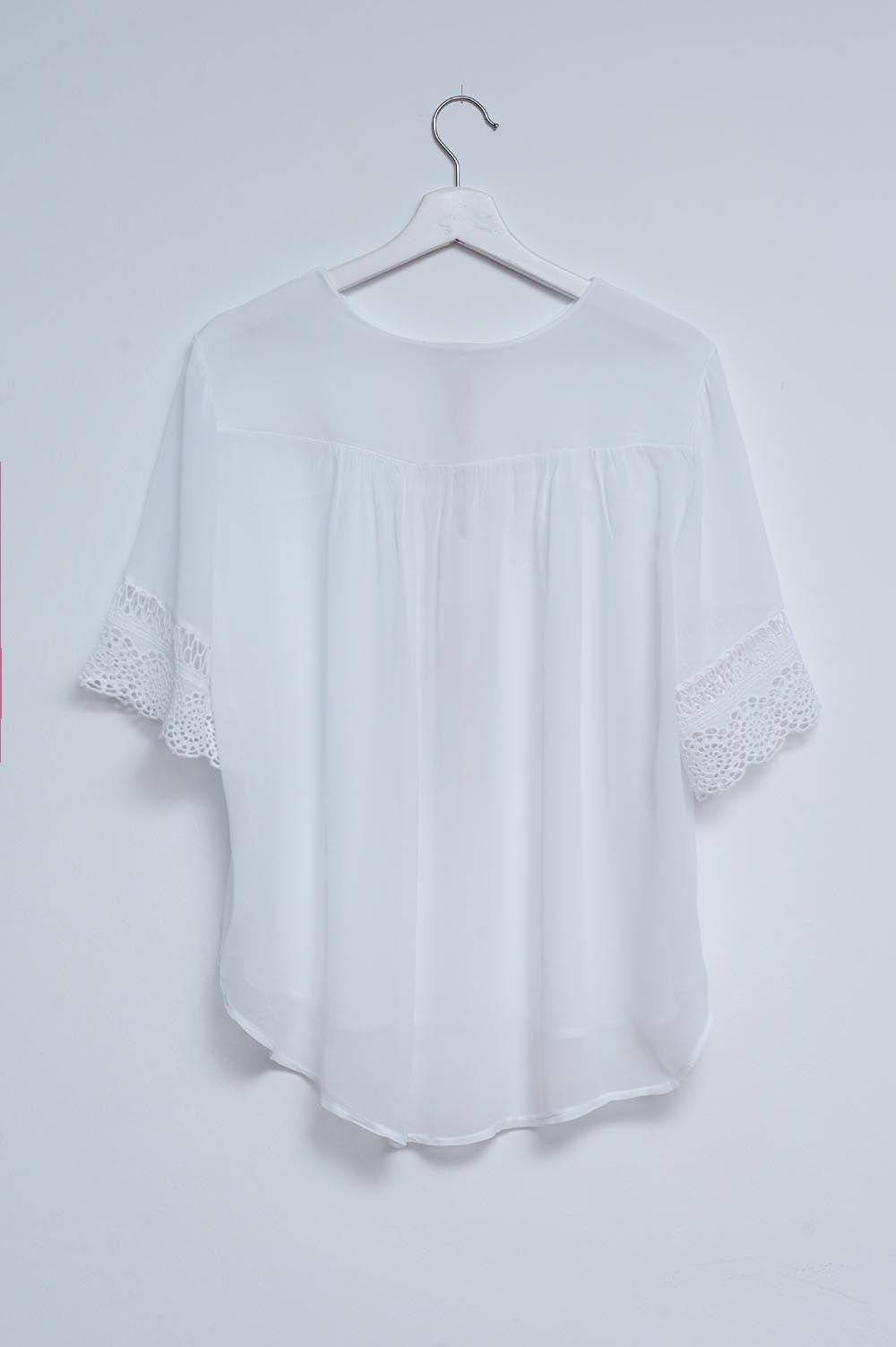 Blusa branca com laçada na frente e bordados