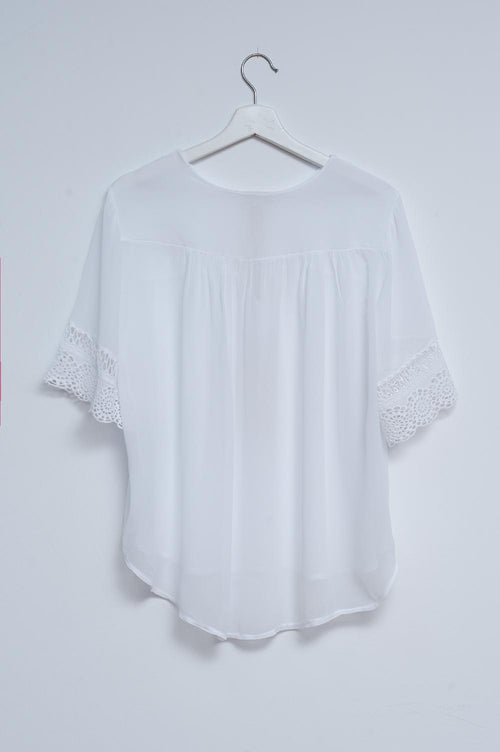 Blusa branca com laçada na frente e bordados