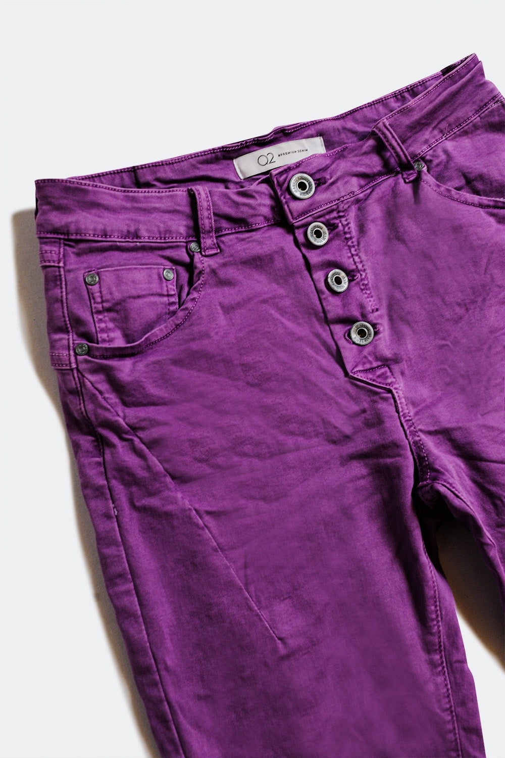 Calças de ganga skinny púrpura com fecho de botão exposto