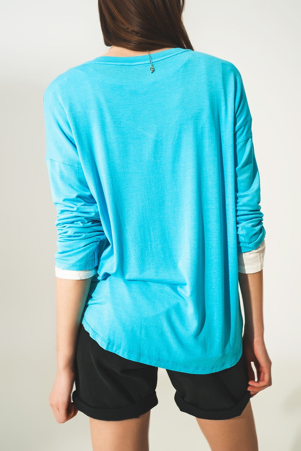 Top de manga comprida em modal azul com decote em V preto