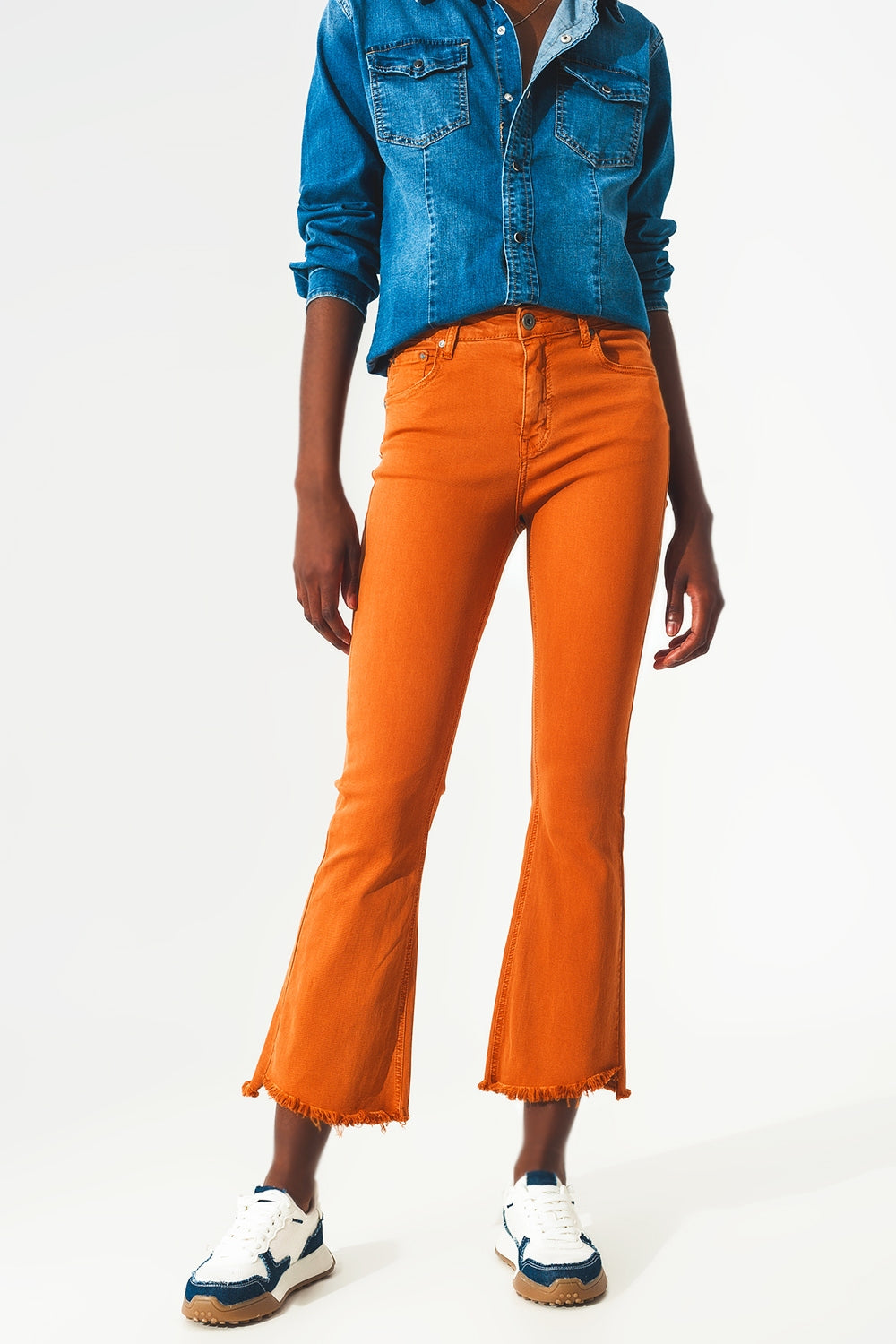 Calças jeans flare com bainha desfiada em laranja