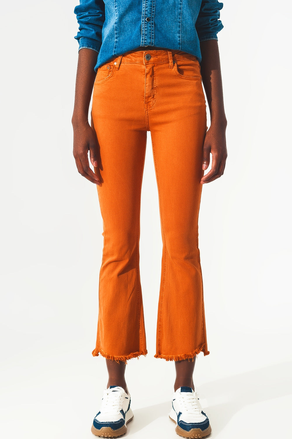 Calças jeans flare com bainha desfiada em laranja
