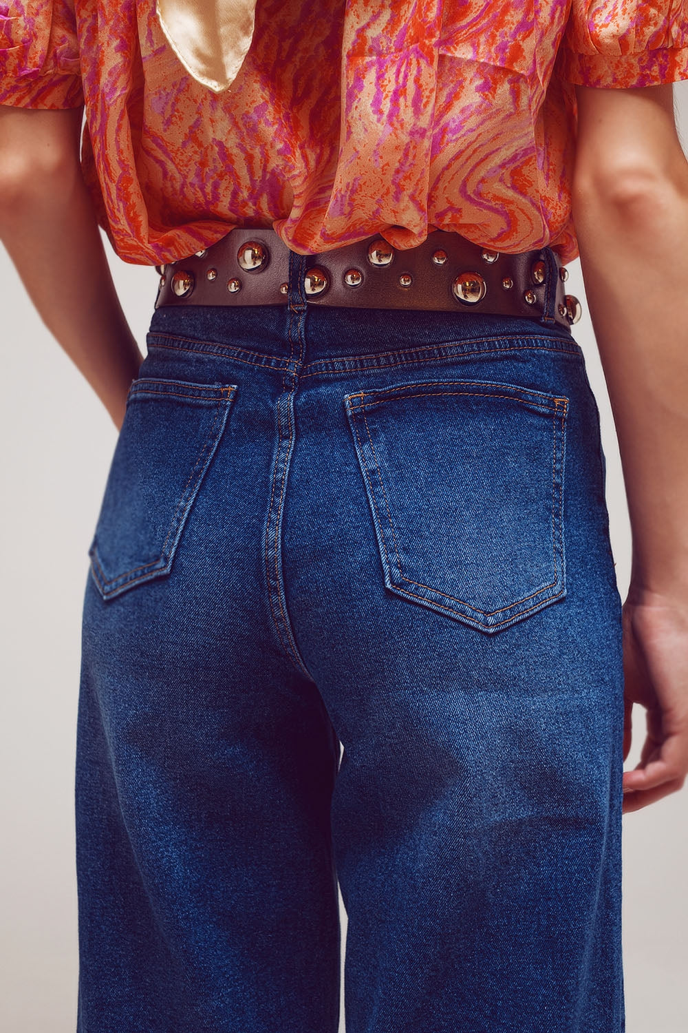 Calça jeans de perna larga com detalhe na barra em lavagem média