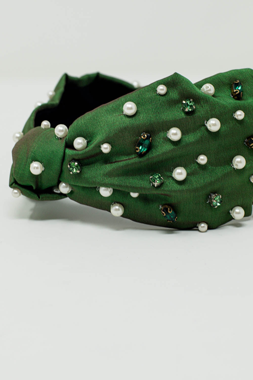 Diadema adornada com jóias brancas e verdes com nó ao meio