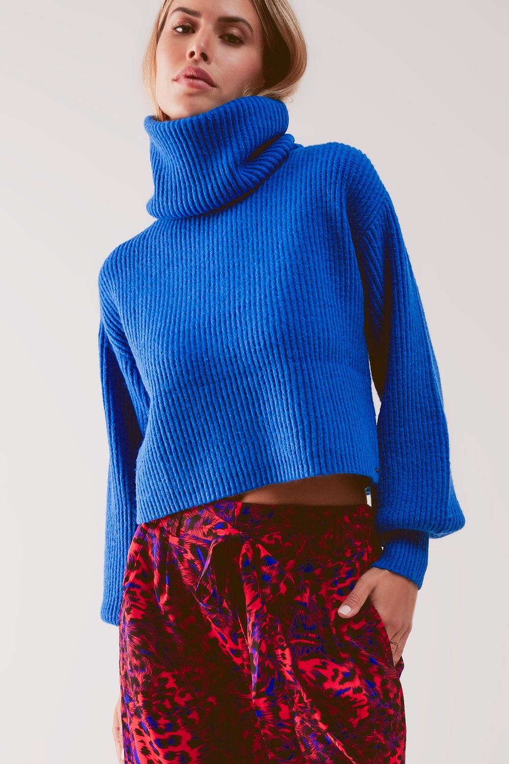 Camisola de gola alta em malha azul com mangas balão.