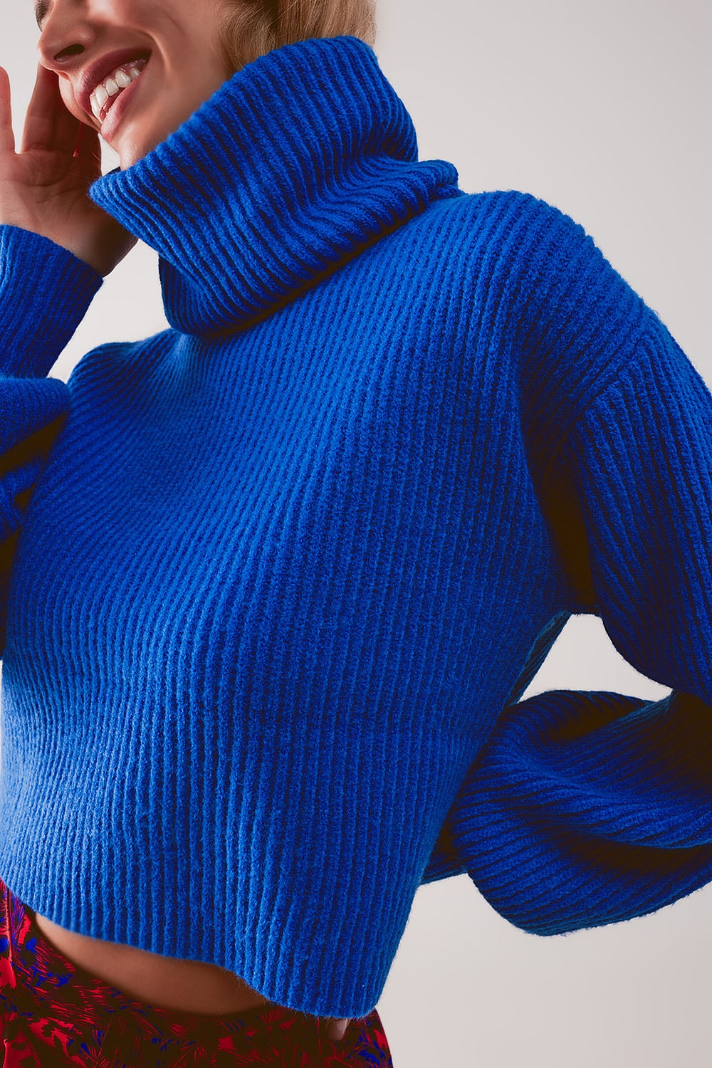 Camisola de gola alta em malha azul com mangas balão.