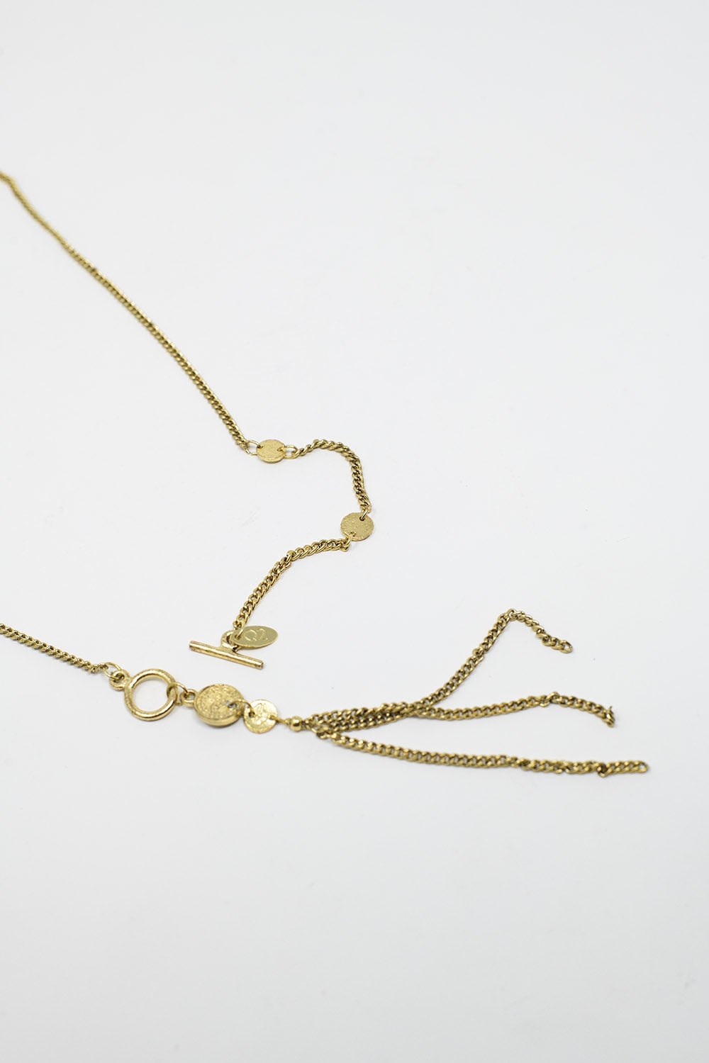Colar dourado com contas e pormenor de corrente com franjas