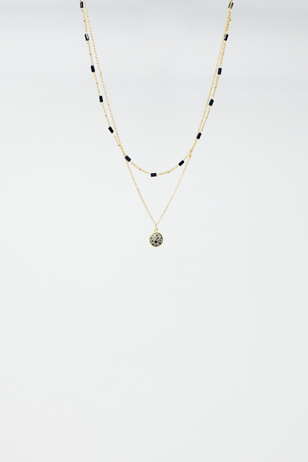 Colar curto 2 em 1 em ouro com contas pretas e pedra branca marmoreada.