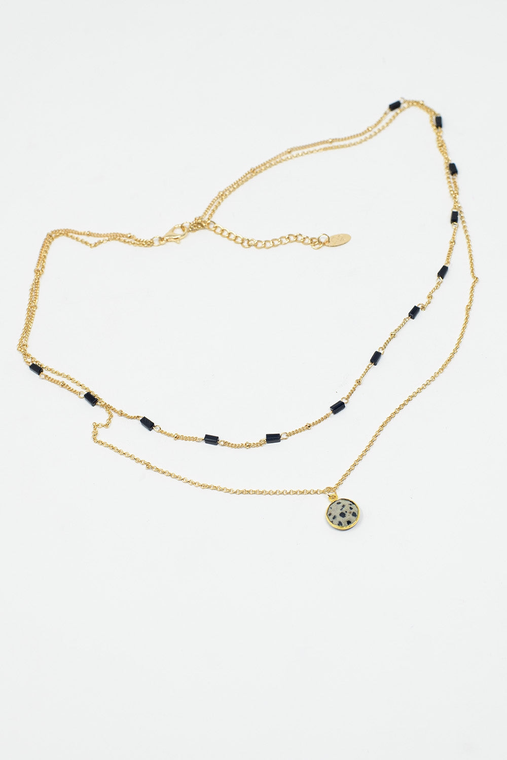 Colar curto 2 em 1 em ouro com contas pretas e pedra branca marmoreada.
