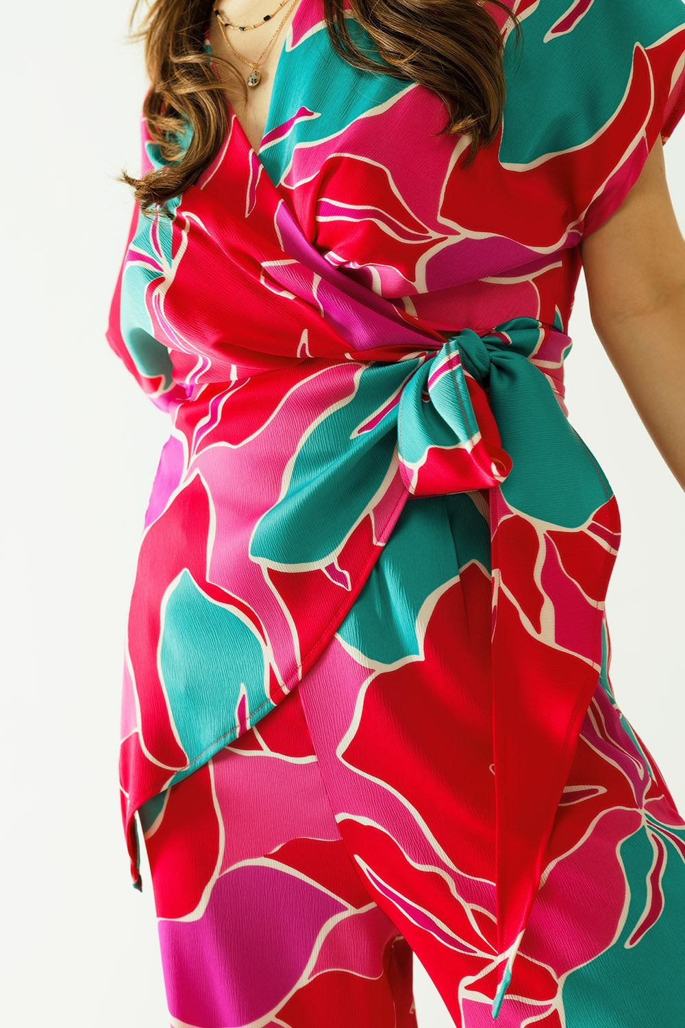 Top de manga curta com design floral e um pormenor de nó