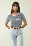 T-shirt branca com riscas pretas e texto Love More