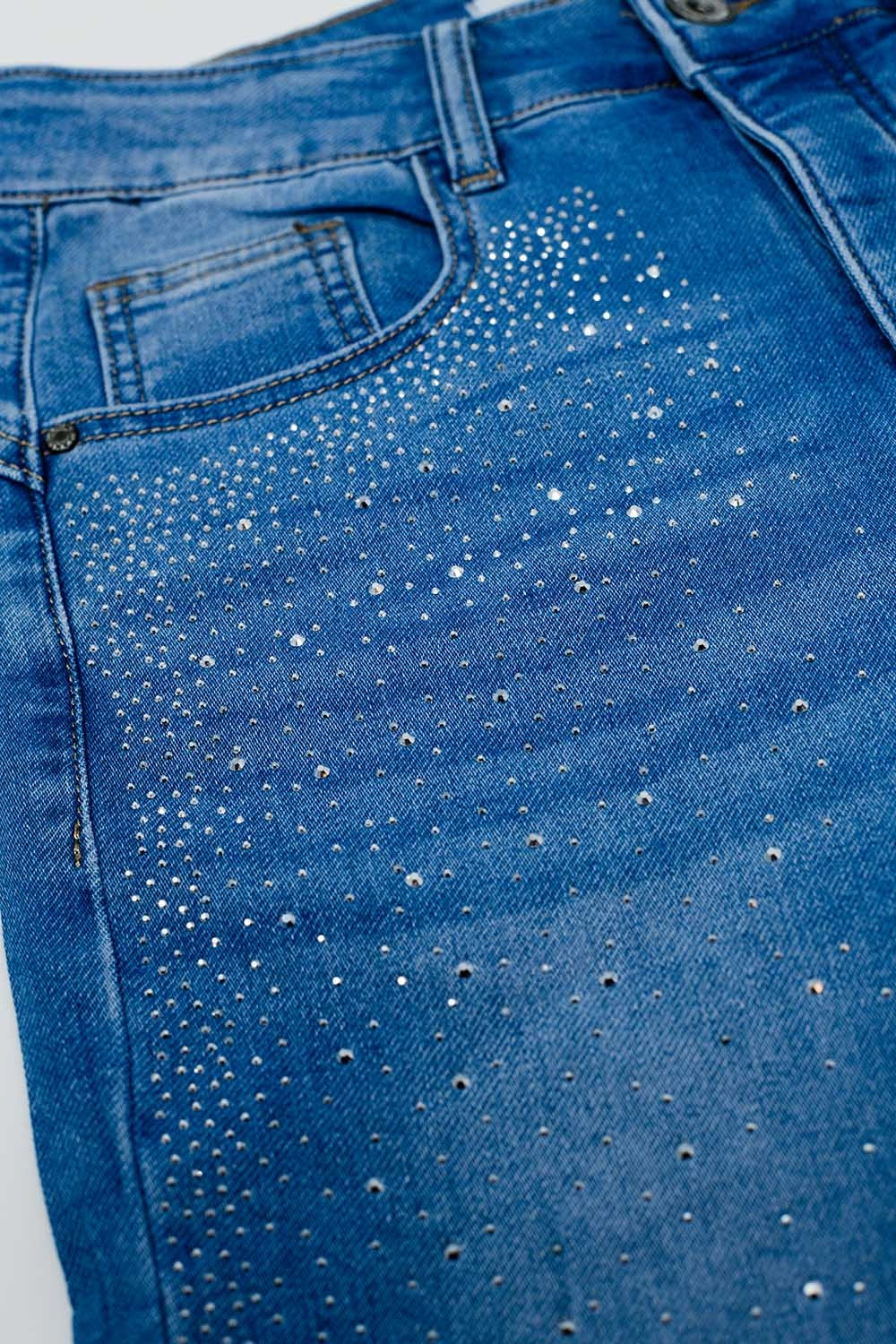 Calças de ganga skinny em azul lavado com strass na parte da frente