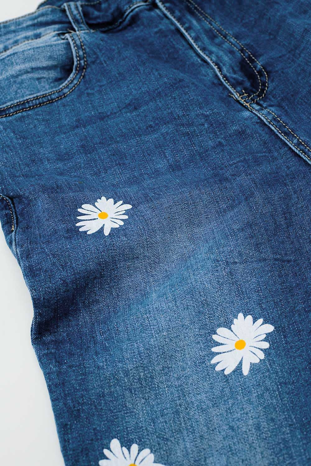 Calças de ganga skinny com margaridas brancas estampadas em lavagem média