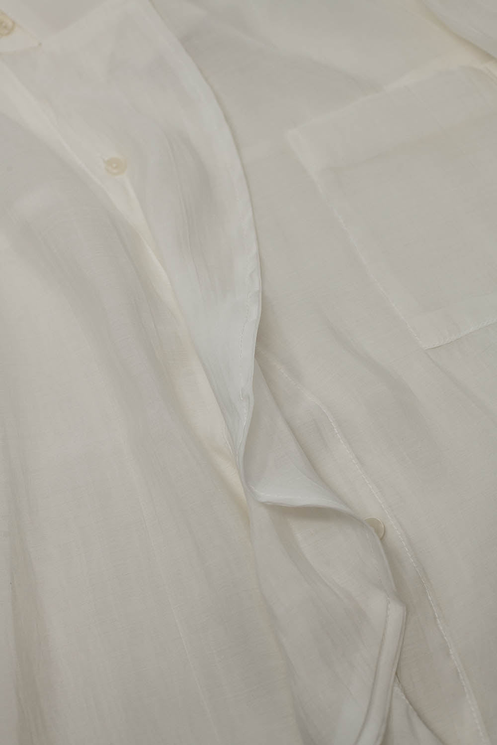 Blusa branca semi-transparente com pormenor de folhos na frente