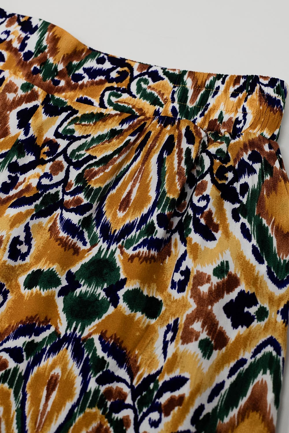 Calças multicoloridas com estampado de flores em laranja e azul
