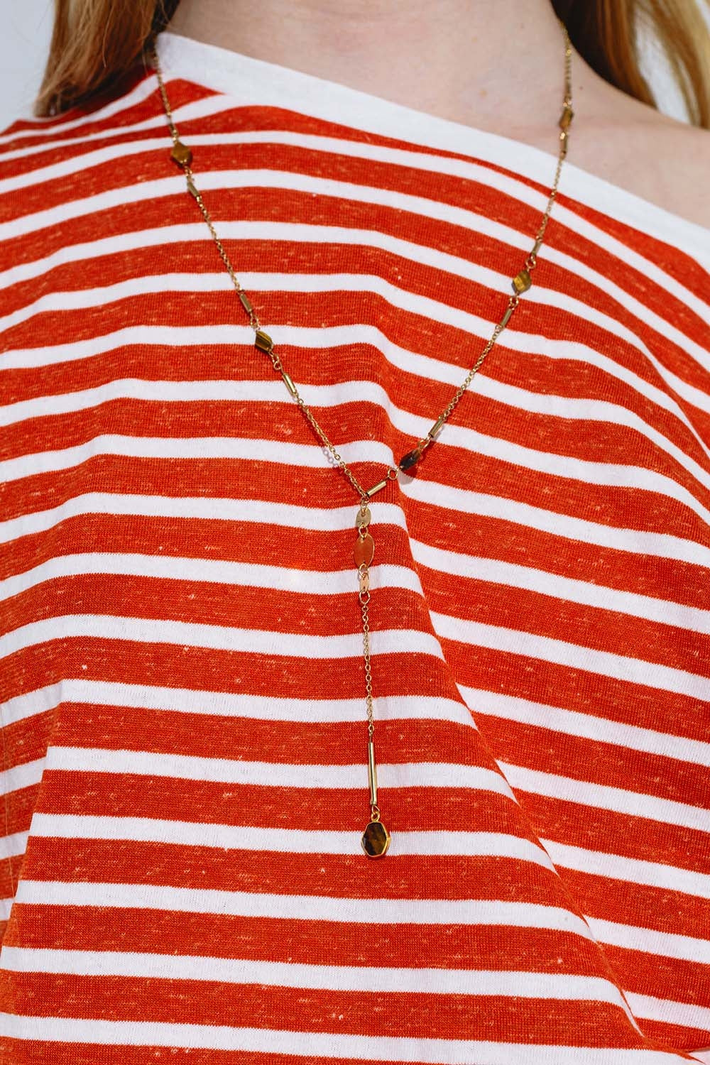 Colar dourado com pormenor de pedra e pendente