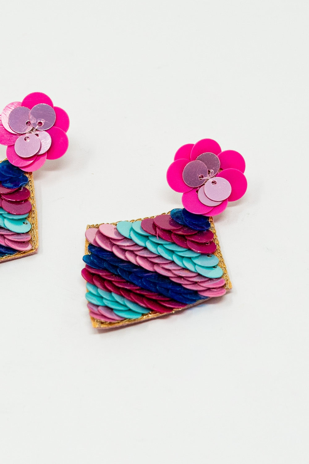 Brincos em forma de diamante com pormenores de lantejoulas multicoloridas.