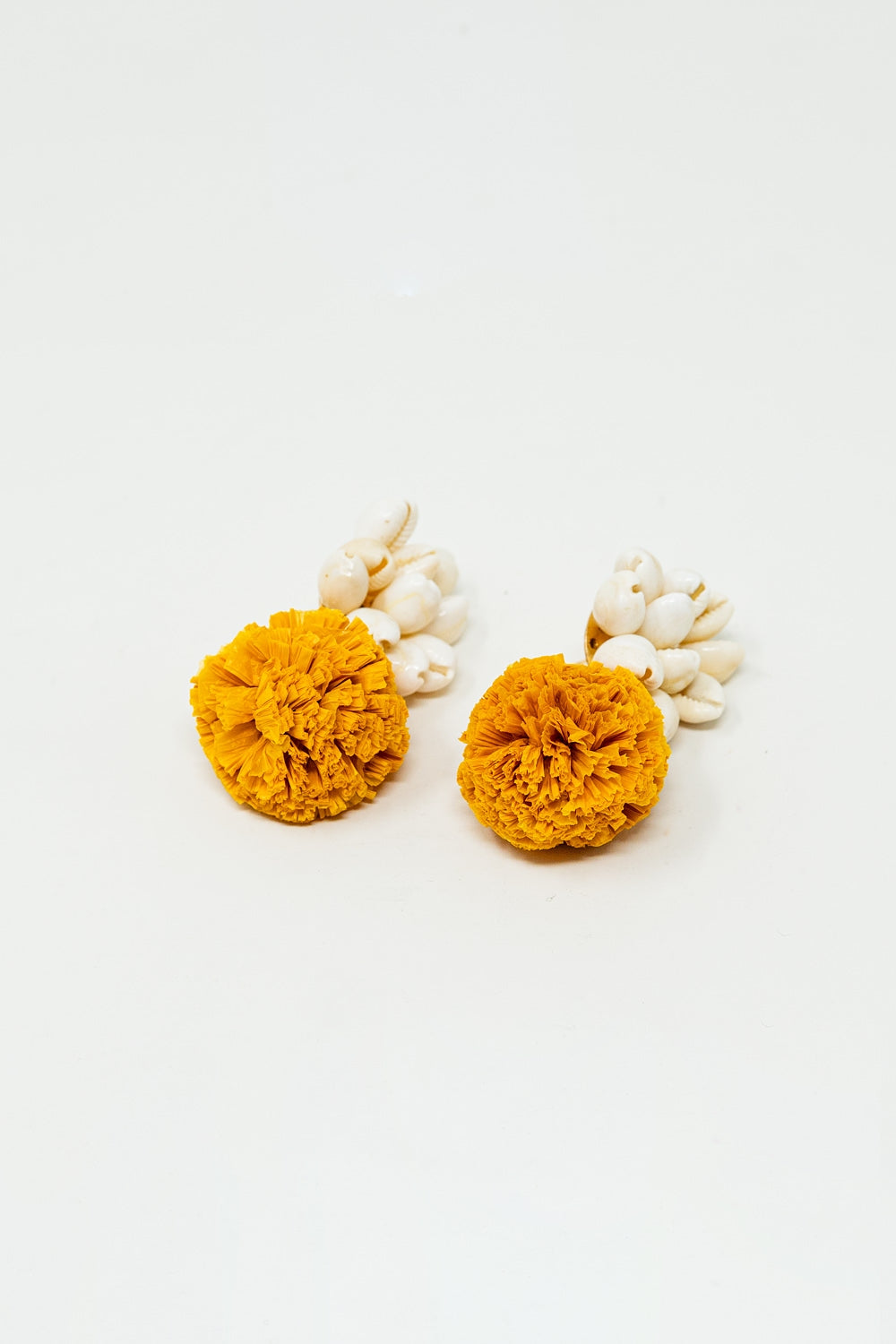 Brincos com conchas creme e pompons amarelos