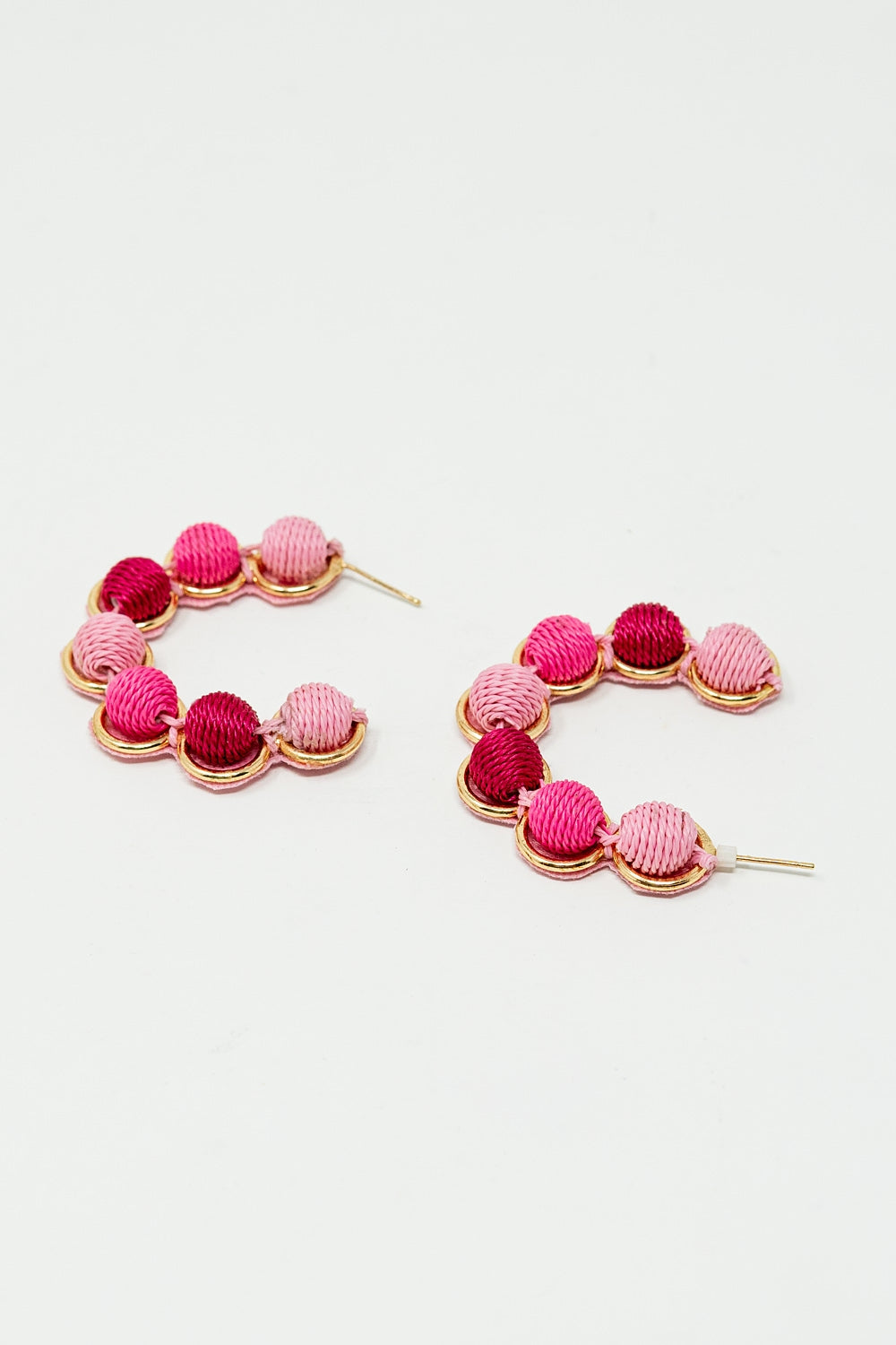 Brinco de argola em ouro com esferas de lã em rosa e fúcsia