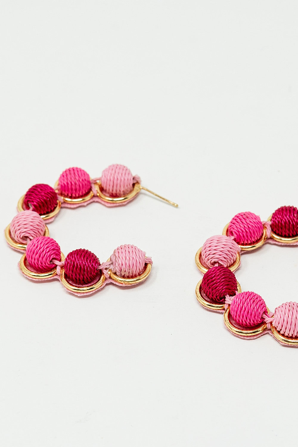 Brinco de argola em ouro com esferas de lã em rosa e fúcsia