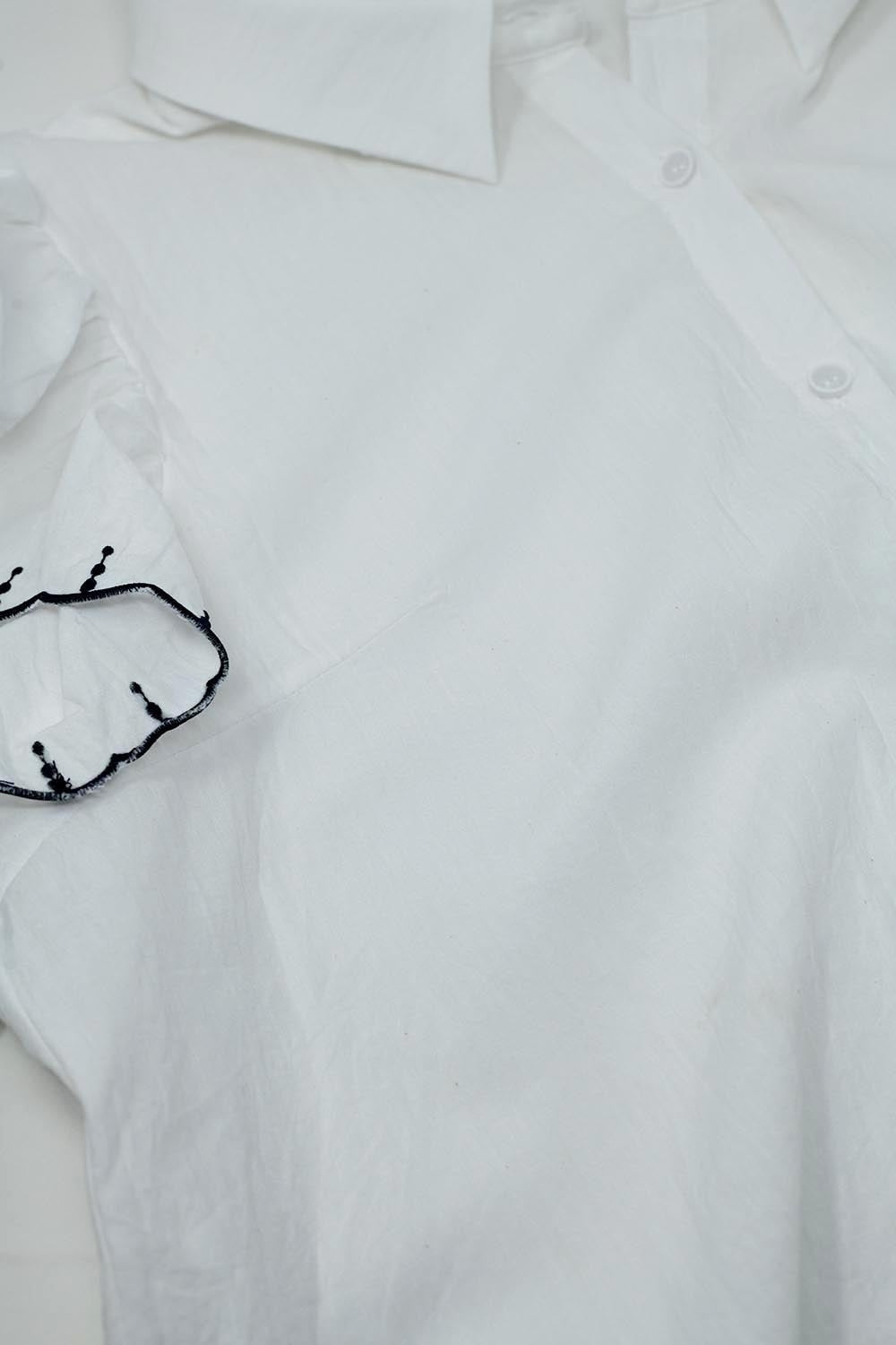 Camisa branca com botões gola polo e mangas com folhos e rebordo preto