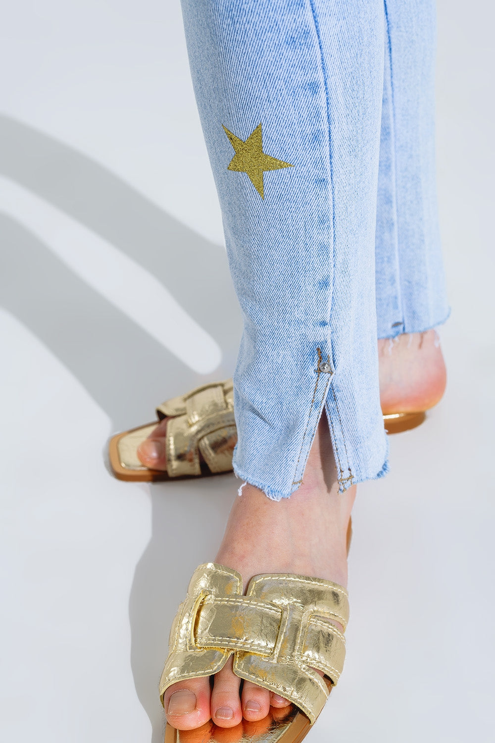 Calças de ganga skinny de lavagem clara com estrelas nas pernas