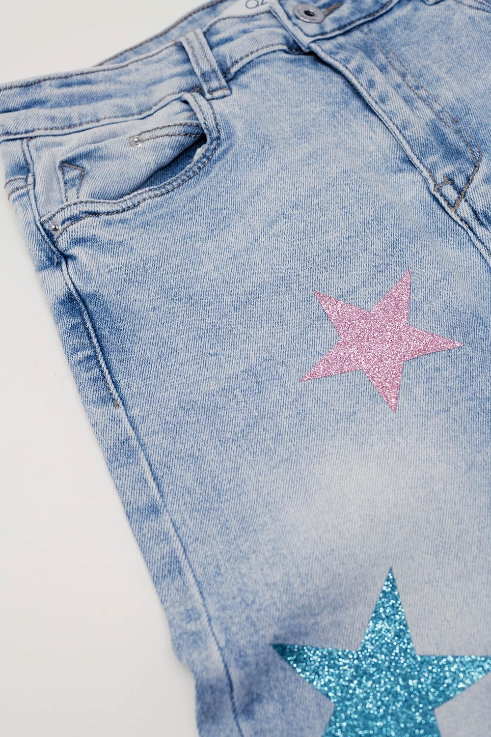 Calças de ganga skinny de lavagem clara com estrelas nas pernas