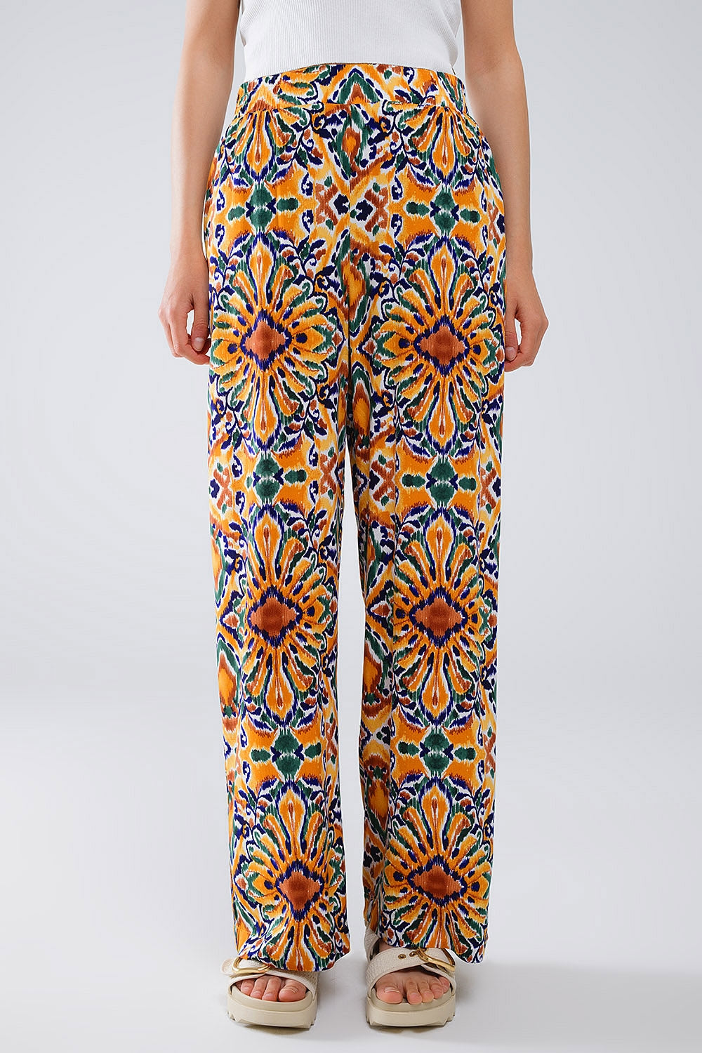 Calças multicoloridas com estampado de flores em laranja e azul