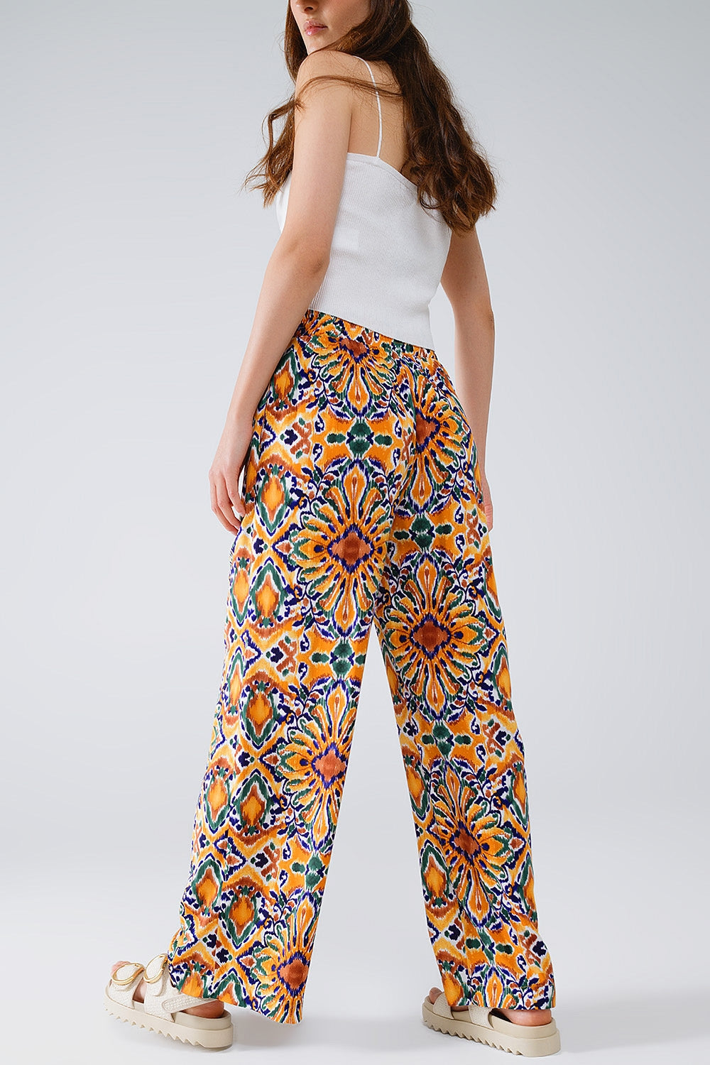 Calças multicoloridas com estampado de flores em laranja e azul