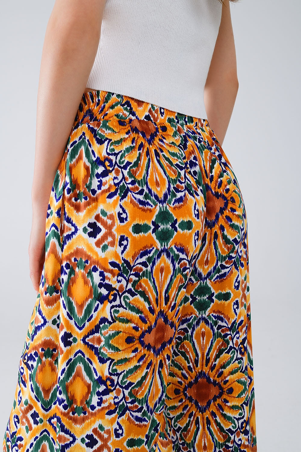 Calças multicoloridas com estampado de flores em laranja e azul