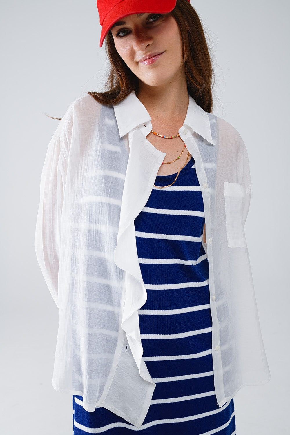 Blusa branca semi-transparente com pormenor de folhos na frente