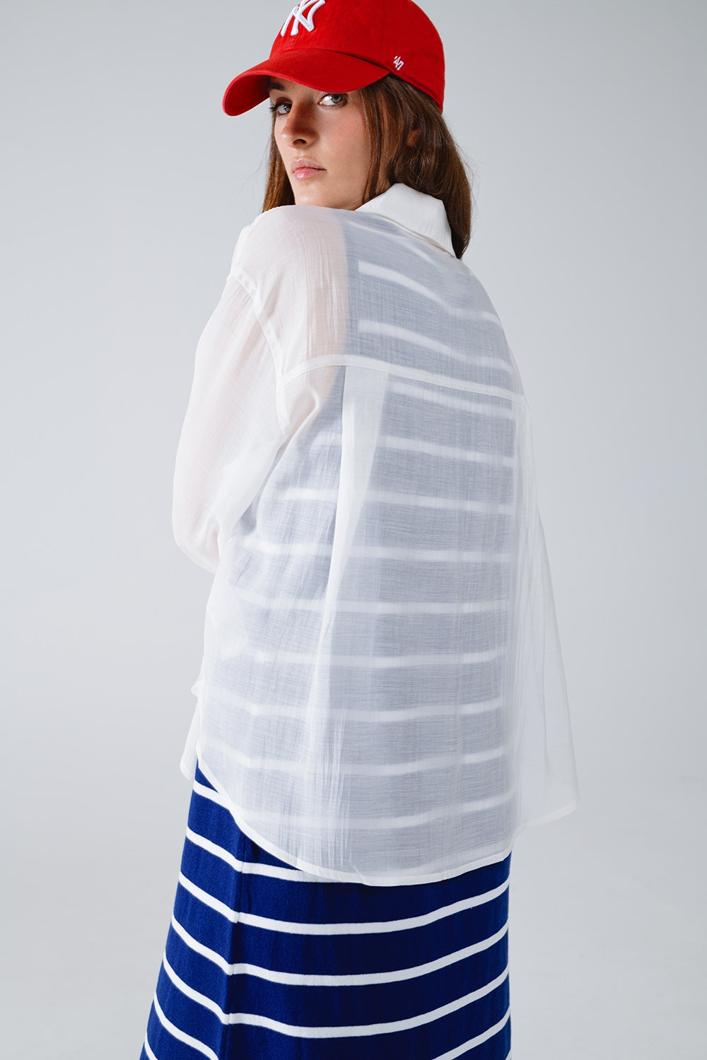 Blusa branca semi-transparente com pormenor de folhos na frente